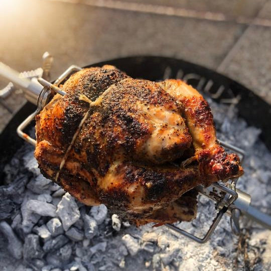 whole humanely raised chicken cooked over fire 